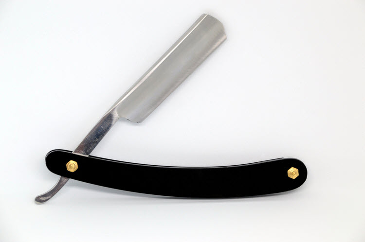 Straight razor with black scales on a white background