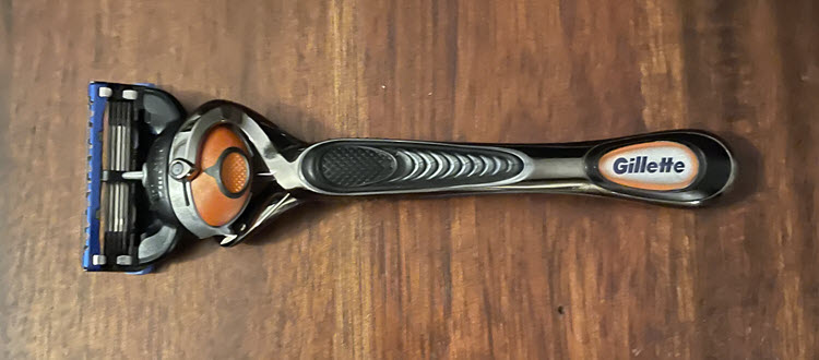 A Gillette Fusion Proglide razor on a wood surface